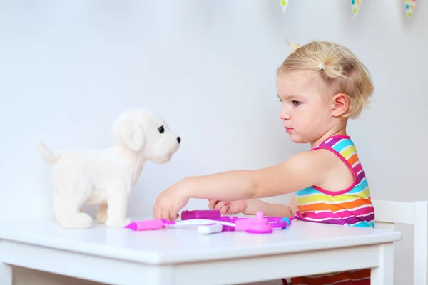 Little girl playing doctor with toys