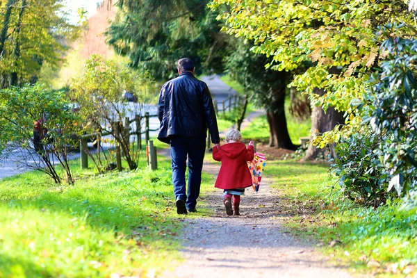 Father with little daughter walking together in the park