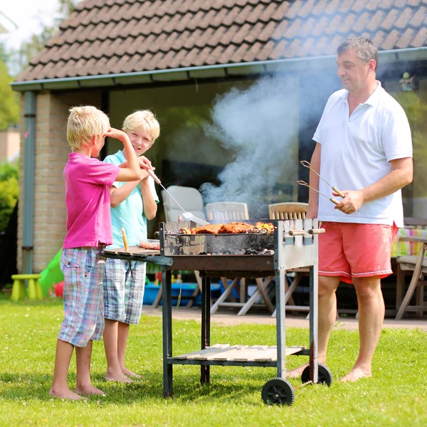 Father and sons preparing barbecue for summer party