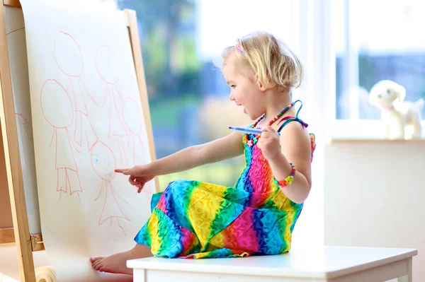 Preschooler girl drawing on paper roll
