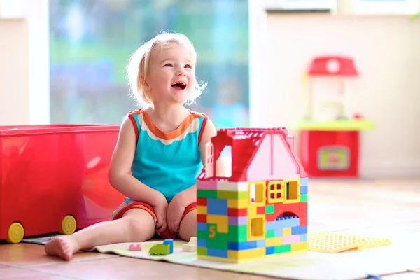 Little girl playing with construction blocks