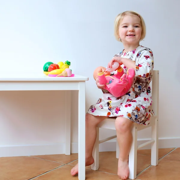 Toddler girl playing with dolls indoors