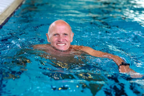 Active senior man swimming in the pool