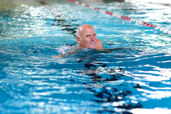 Active senior man swimming in the pool
