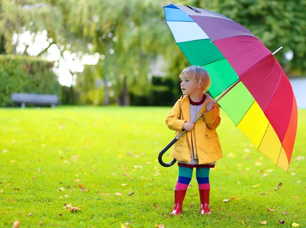 Portrait of playful little girl with colorful umbrella