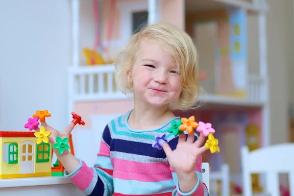 Preschooler girl playing indoors with educational toys