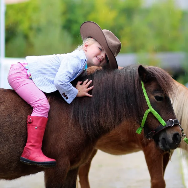 Happy little girl and her pony