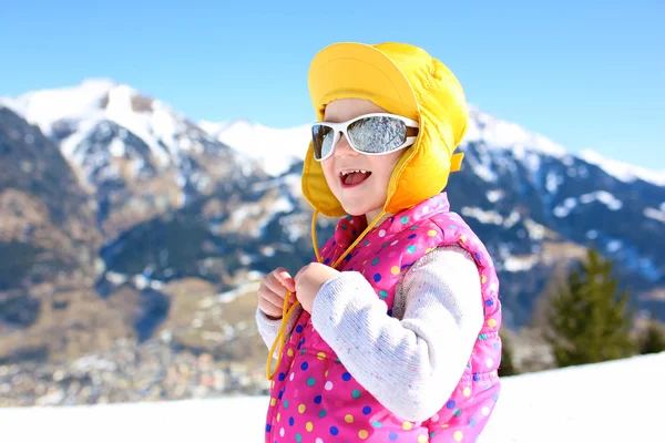 Little girl enjoying winter vacation at Alpine ski resort