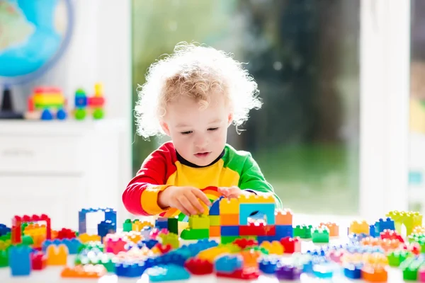 Little boy playing with plastic blocks