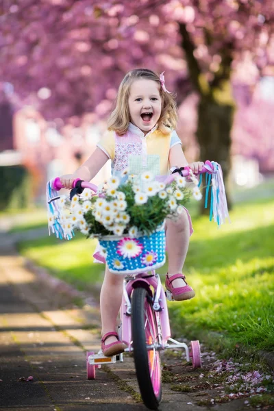 Little girl riding a bike on sunny spring day