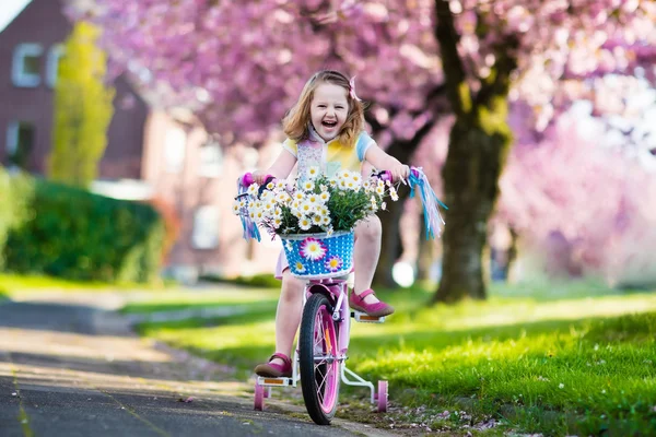 Little girl riding a bike on sunny spring day