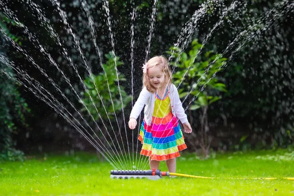 Kids playing with garden sprinkler