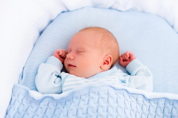 Newborn baby boy in white bassinet