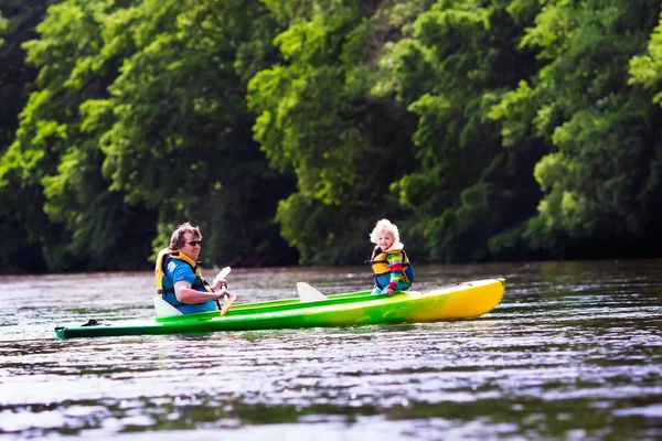 Father and child kayaking in summer