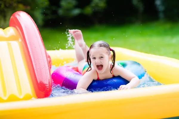 Little girl in garden swimming pool