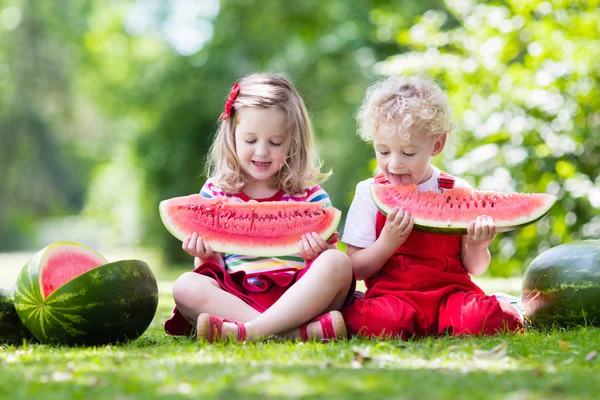 Kids eating watermelon in the garden