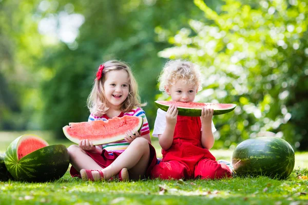 Kids eating watermelon in the garden