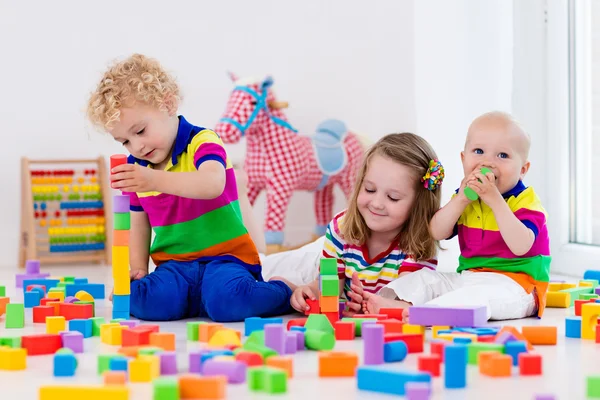 Kids playing with colorful toy blocks