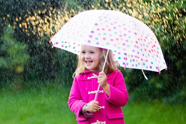 Little girl with umbrella in the rain