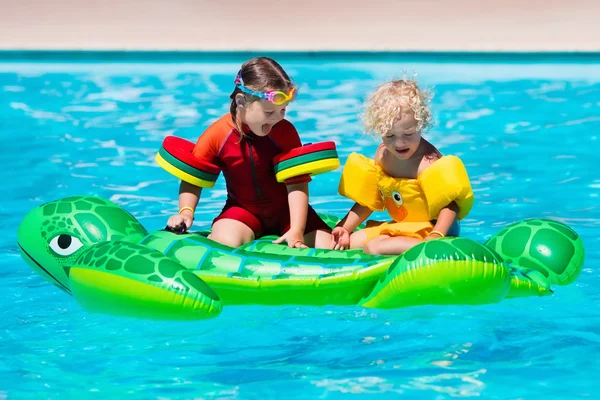 Kids in swimming pool with inflatable toy