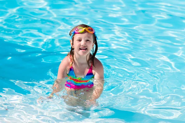 Child learning to swim in pool