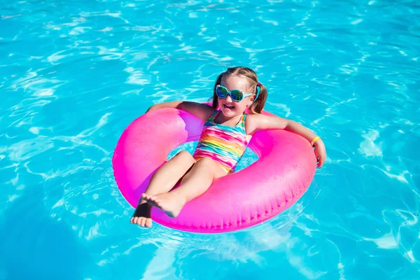 Little girl with toy ring in swimming pool