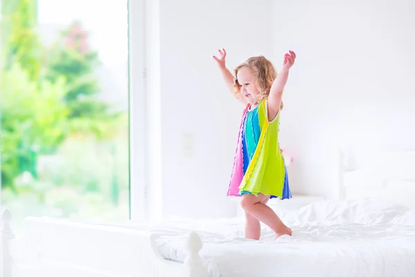 Little girl jumping on a bed