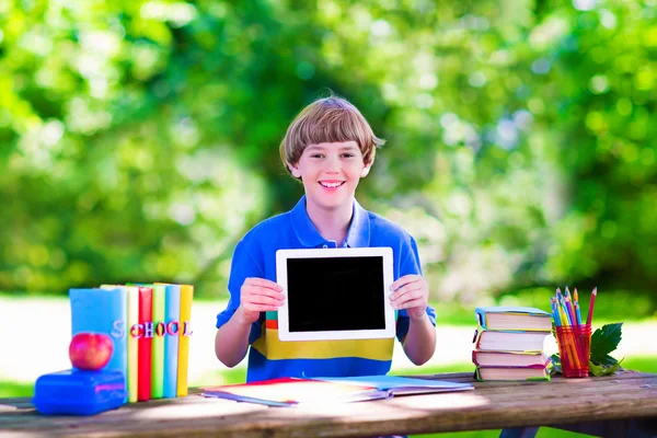 Child with tablet computer on school yard