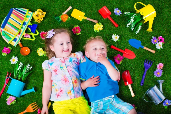 Kids on a lawn with garden tools