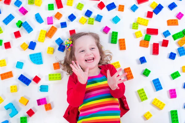 Little girl playing with colorful blocks