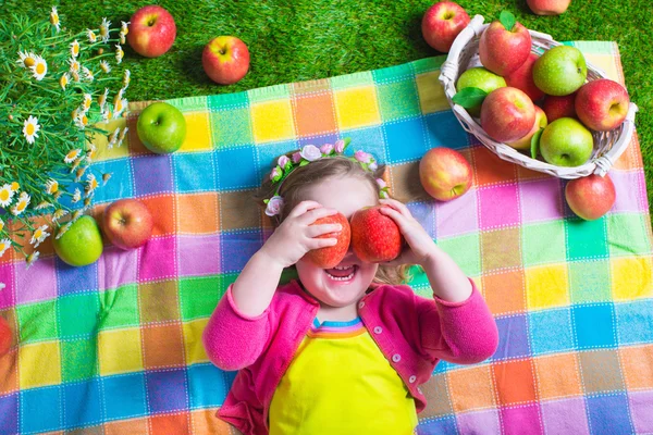 Little girl eating apples