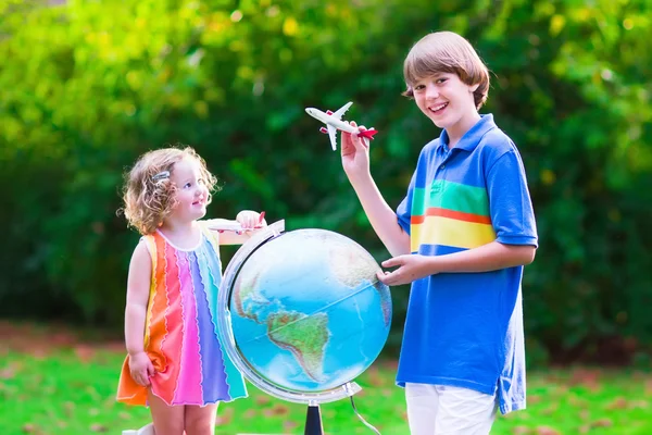 Kids playing with airplanes and globe