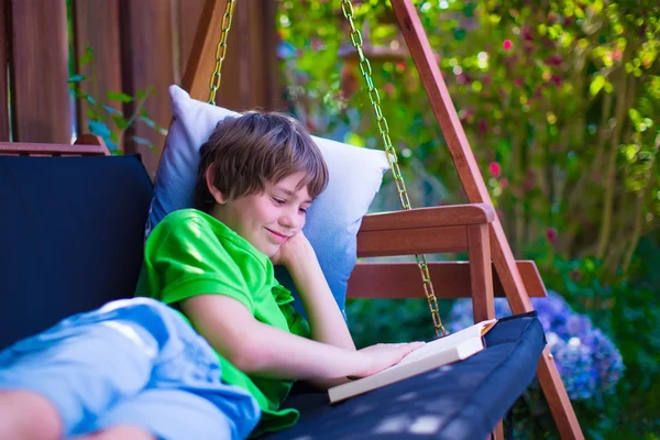 Child reading a book in the garden