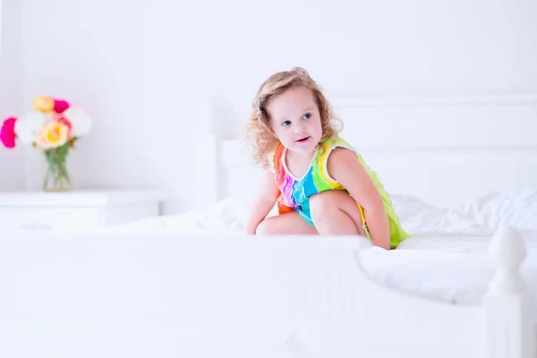 Little girl jumping on a bed