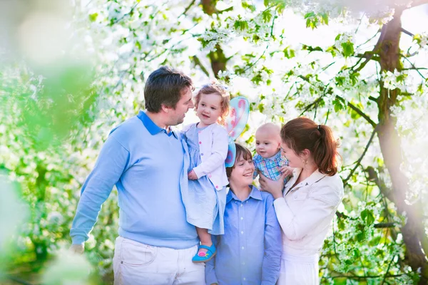 Happy family in a blooming cherry tree garden