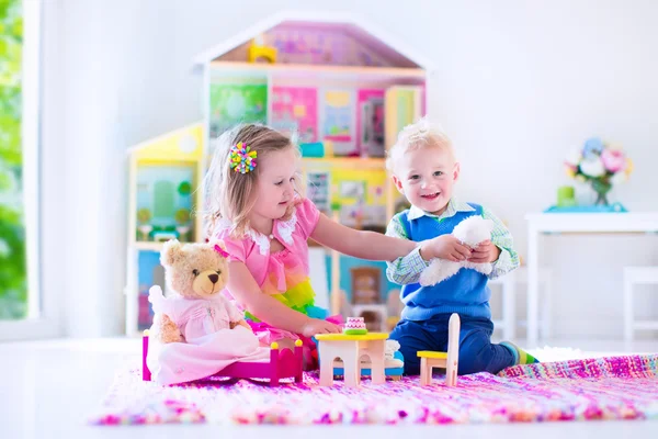 Kids playing with stuffed animals and doll house