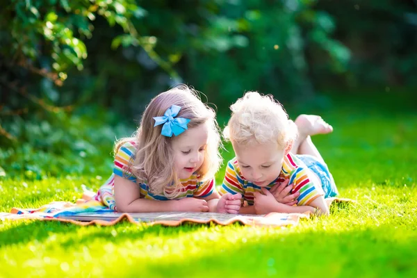 Two kids reading in summer garden