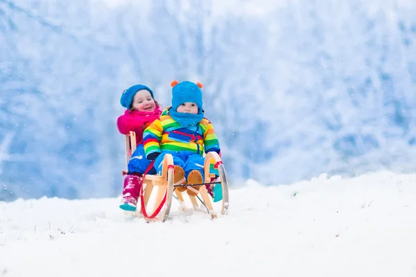 Kids riding sleigh in winter park