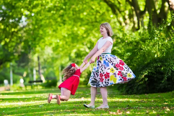 Young woman playing with little girl in a park