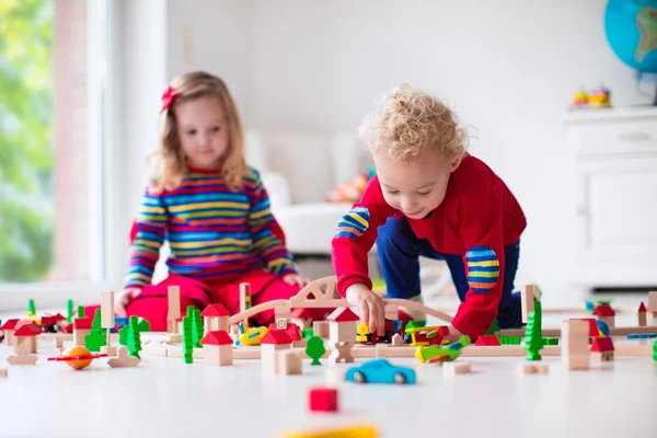 Children playing with toy railroad and train