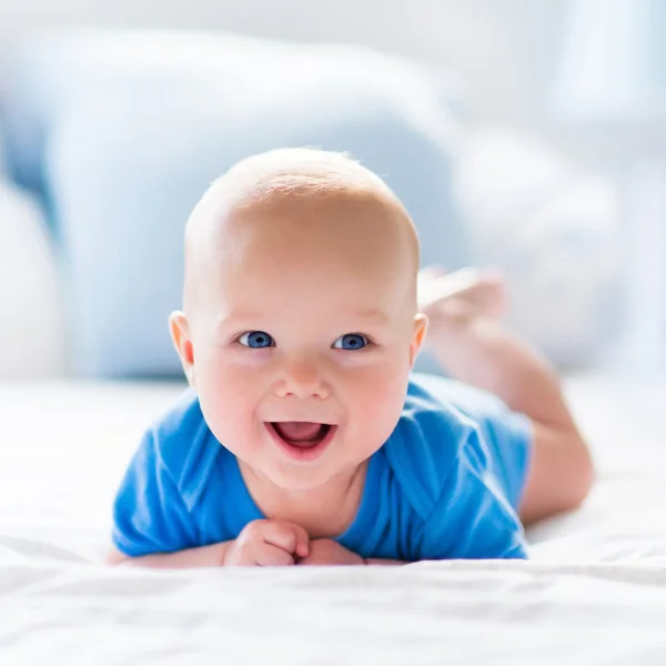 Baby boy in white sunny bedroom