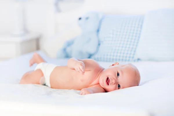 Baby boy on white bed