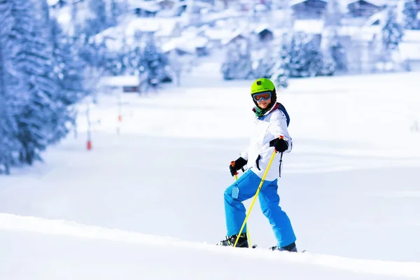 Child skiing in mountains. Active teen age kid with safety helmet, goggles and poles. Ski race for young children. Winter sport for family. Kids ski lesson in alpine school. Skier racing in snow