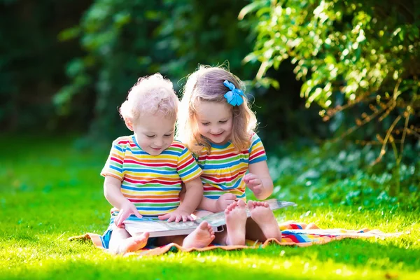 Two kids reading in summer garden