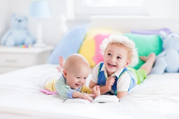 Little brothers reading a book in bed