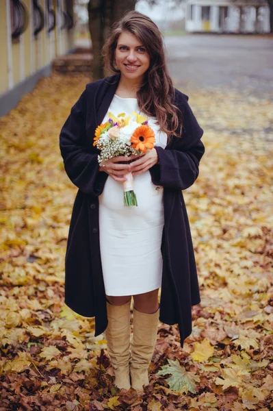 Pregnant girl with a bouquet of flowers