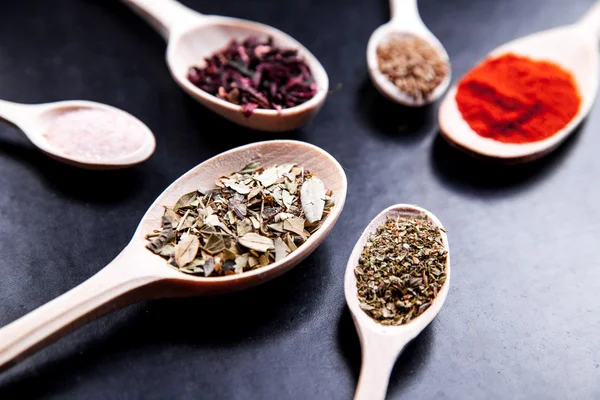 Spice in wood spoon on a black background. food