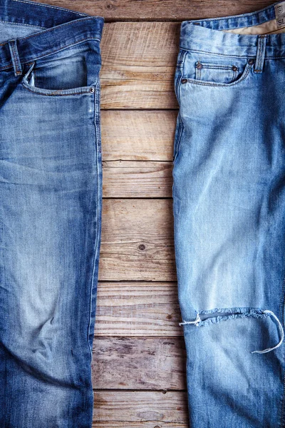 Ripped jeans and a trendy on wooden background. Fashion, style,