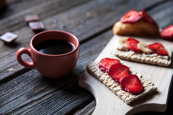 Delicious breakfast with a cup of coffee and fruit sandwiches, croissants. Strawberries, food, drink, chocolate.