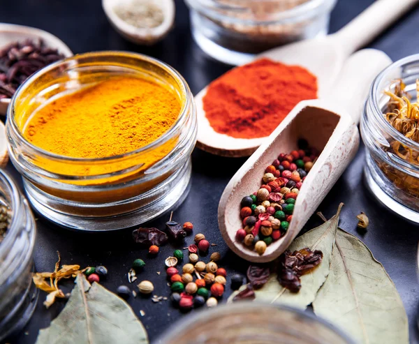 Spices on black background in special jars. Food